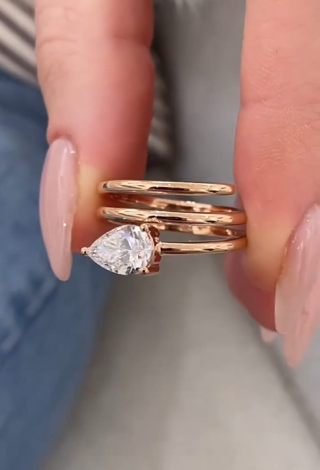Detailed side-angle shot showing the brilliant clarity of a 1.5 carat pear cut lab created diamond on a multi-strand rose gold band.