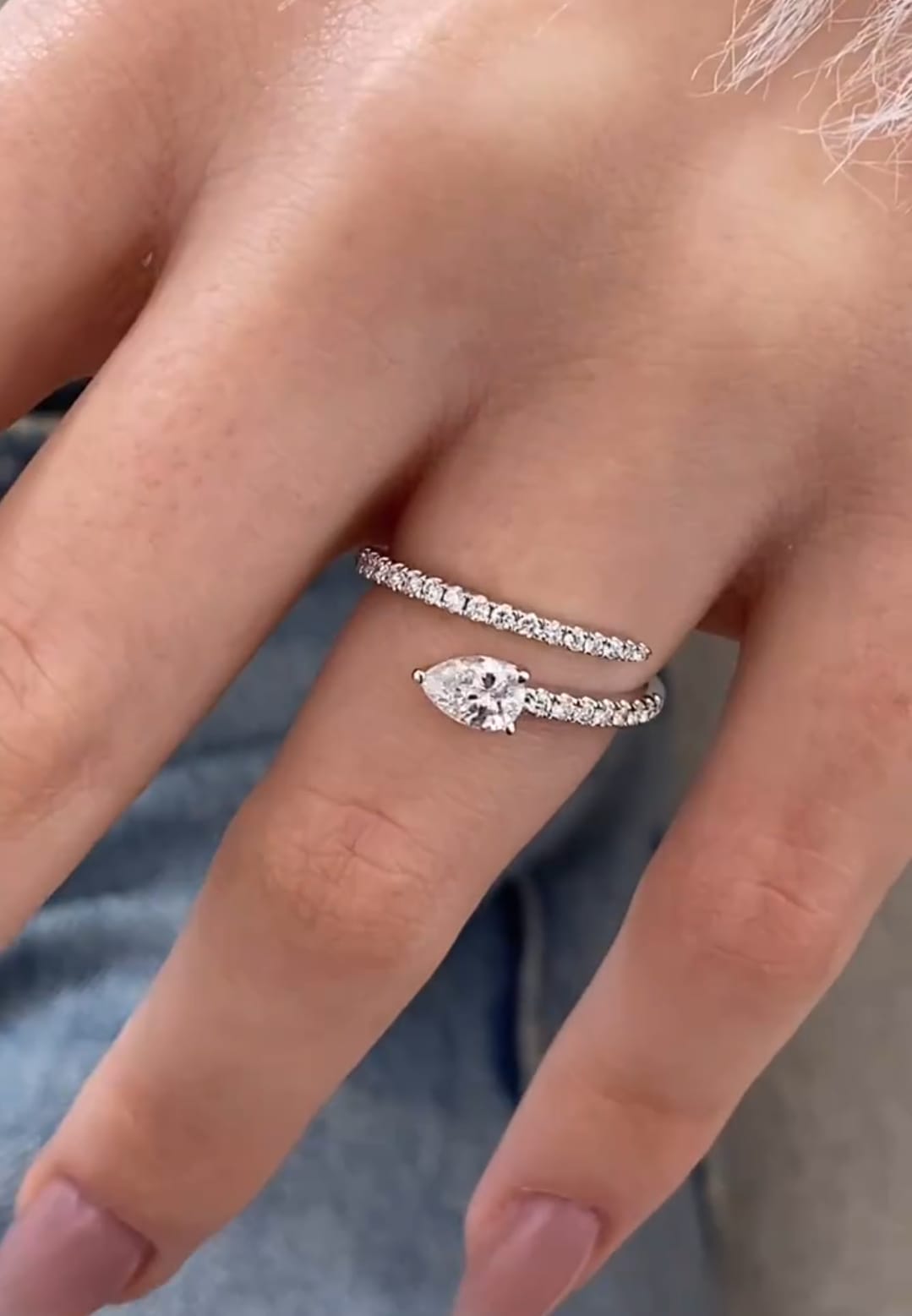 On-hand view displaying a 1.50 CT pear-shaped lab created diamond ring with a sparkling pave wrap design.
