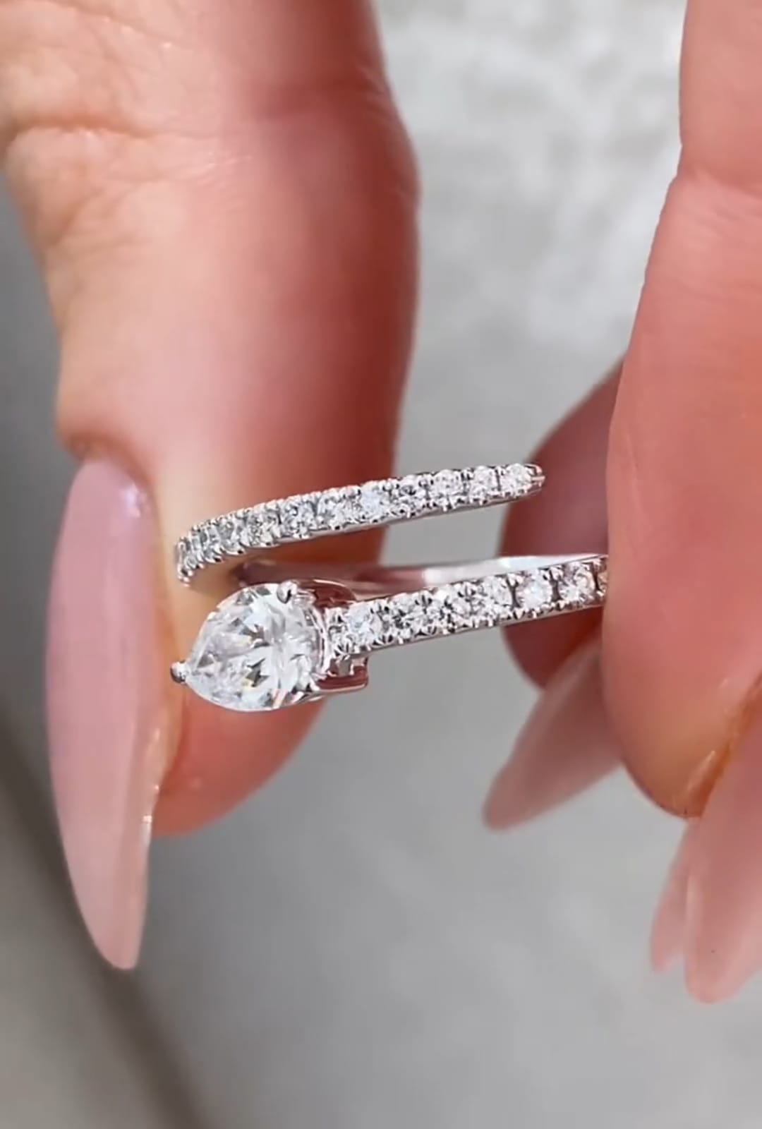 Detailed side-angle shot of a 1.5 CT pear lab grown diamond resting on a double-layer pave diamond band.