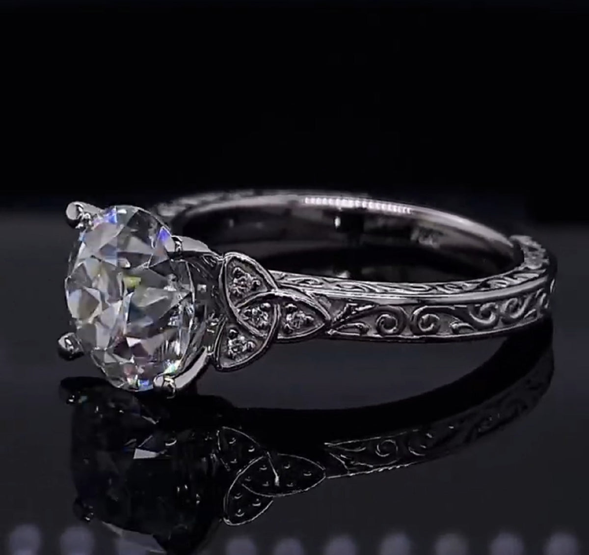 Side angle of 2 carat round lab diamond ring showing Celtic knot shoulders and engraving