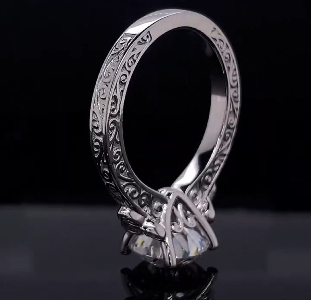 Close-up of carved scrollwork band and head setting on round lab diamond ring