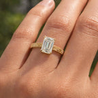 Top-down view on hand of a 3 ct emerald cut lab grown diamond ring with vintage detail