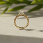 Side profile of yellow gold engagement ring showing intricate band engraving and setting details