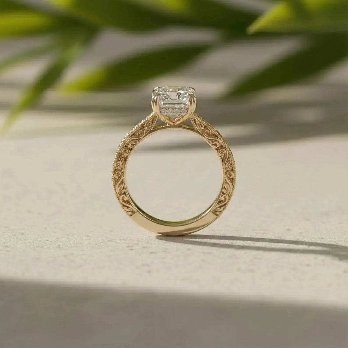 Side profile of yellow gold engagement ring showing intricate band engraving and setting details