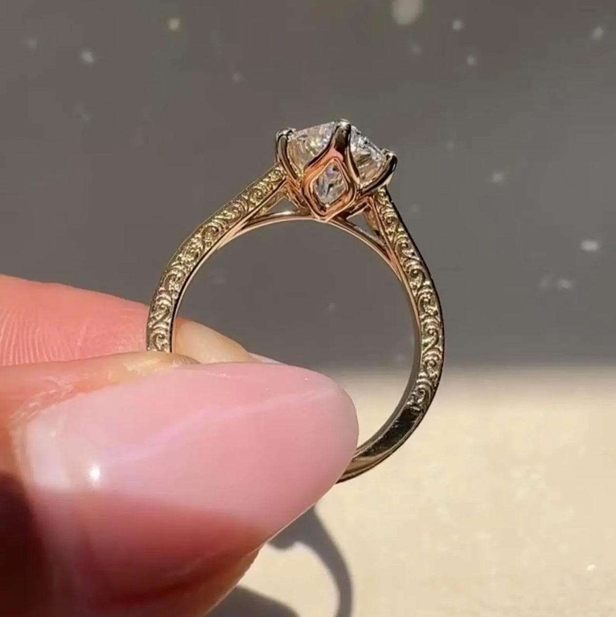 Person holding a 3 carat marquise cut lab created diamond engagement ring showing filigree scrollwork