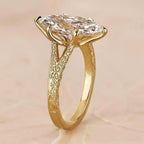 Close-up side profile of yellow gold cathedral engagement ring showing detailed scrollwork engraving