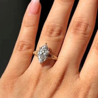 Close-up view on finger of a 3 carat marquise lab grown diamond ring in yellow gold