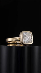 Side angle view of 3 carat cushion cut lab grown diamond bezel set ring resting on black pedestal