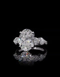 Top front view of a 4 carat oval lab grown diamond ring with heart side accents and pavé diamond band