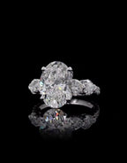 Top front view of a 4 carat oval lab grown diamond ring with heart side accents and pavé diamond band