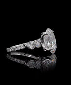 Perspective side view displaying the heart-cut shoulder stones and large oval center lab diamond