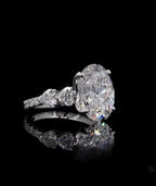 Three-quarter view of a 4 carat oval cut lab diamond engagement ring with heart accents against black background