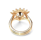 A gold ring with a crown-like floral setting and a clear central gemstone, shown on a plain white background.