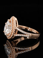 Side profile view of a rose gold pear engagement ring highlighting the open split shank band and raised halo setting.