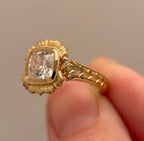 Angled side view displaying textured scalloped bezel halo surrounding 4 CT cushion diamond.