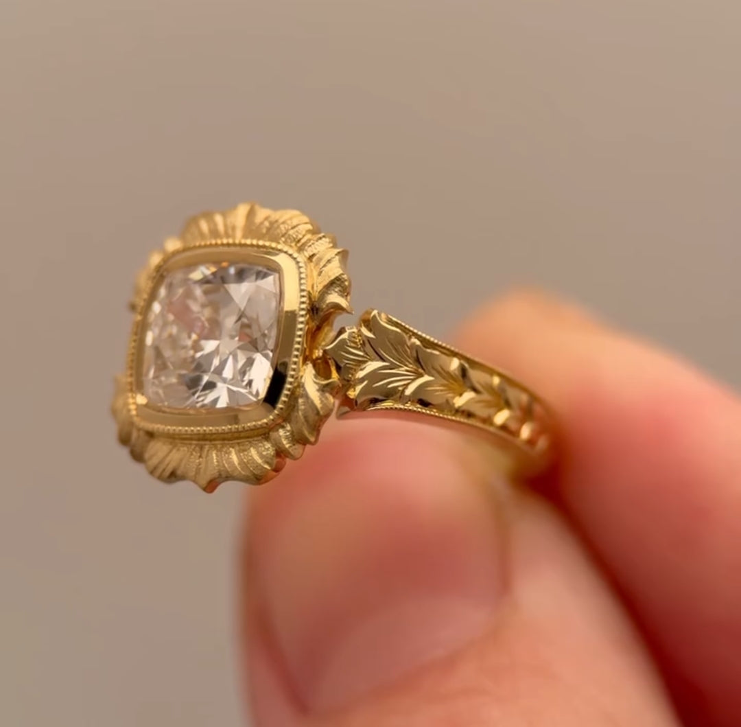Angled side view displaying textured scalloped bezel halo surrounding 4 CT cushion diamond.