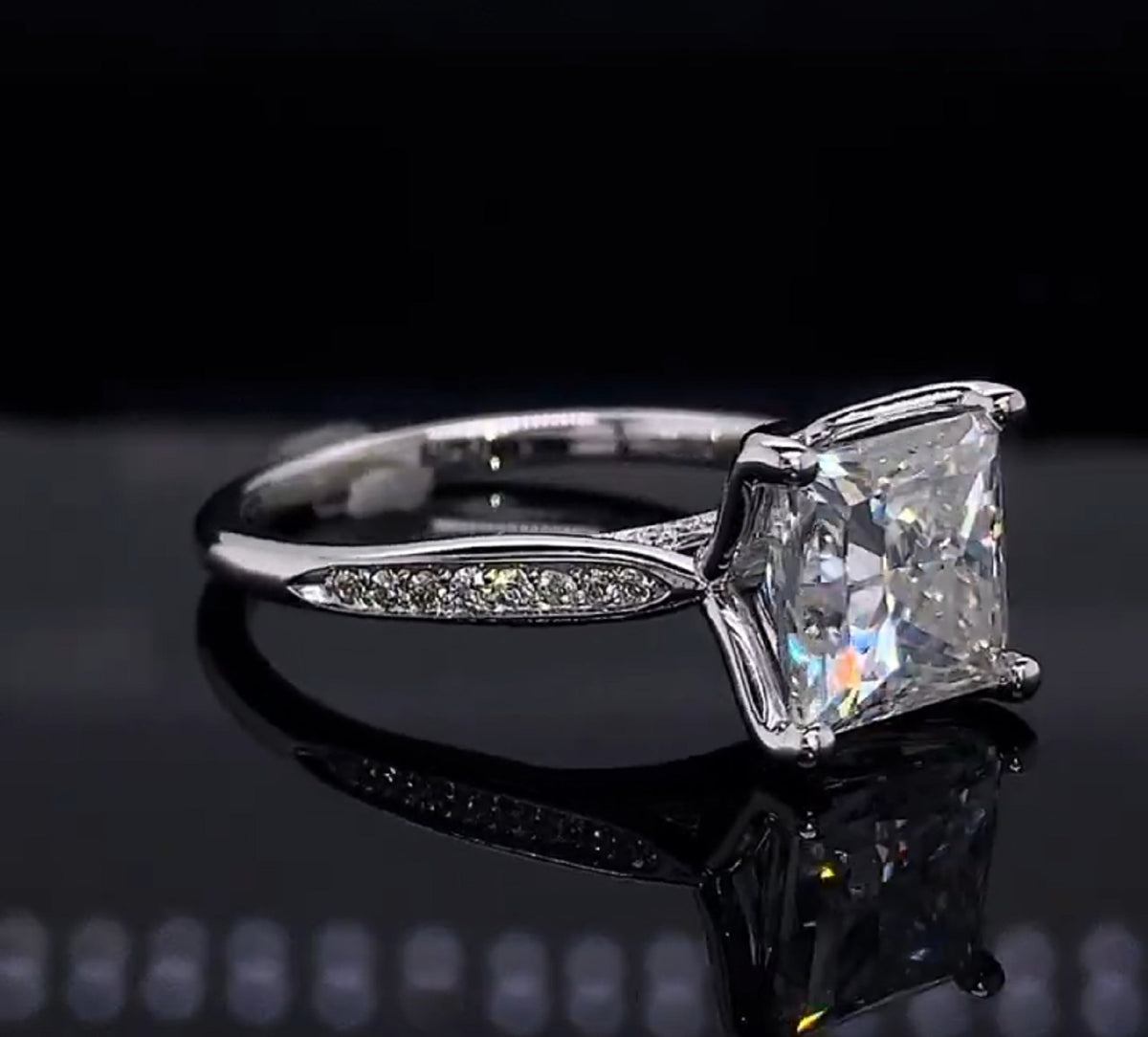 Angled shot showing pavé diamond accents on a 3ct princess cut white gold ring