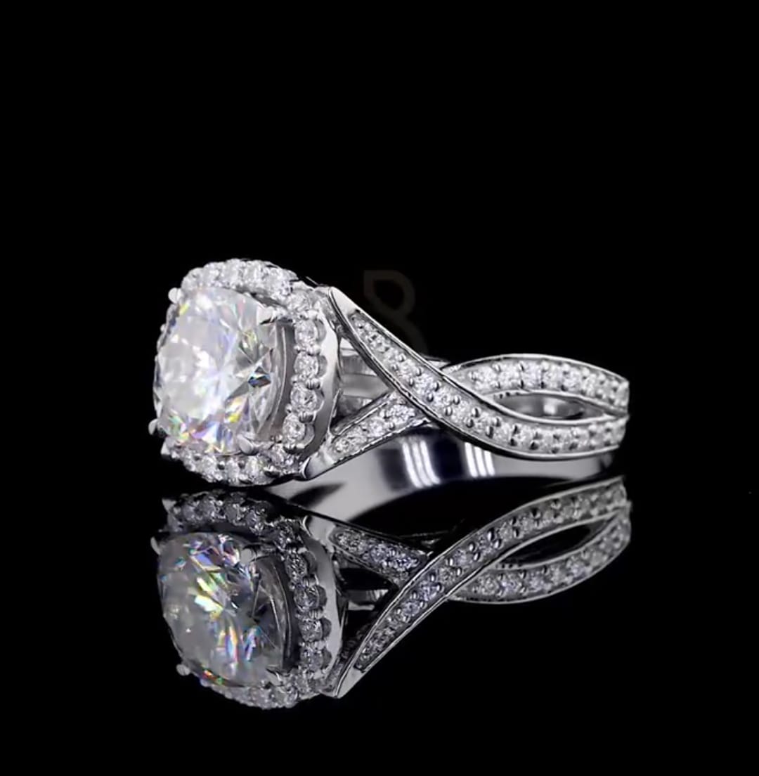 Angled top-side view emphasizing the brilliance of the cushion cut center stone and the interwoven diamond band.