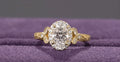 Top-down view of a 2 carat oval cut lab grown diamond engagement ring with a diamond halo and marquise accents.