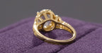 Under-gallery view of a yellow gold oval diamond engagement ring showing the structural setting and intricate band.