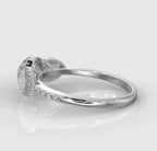 Side profile of a 2 carat round and pear three-stone diamond ring showcasing its elegant low-profile setting.