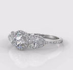 Angled front view of a stunning three-stone halo lab grown diamond engagement ring with a pave diamond band.