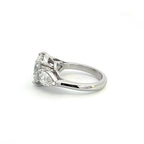 Side profile view of a 3 carat round and pear three-stone lab grown diamond engagement ring with a smooth polished band.