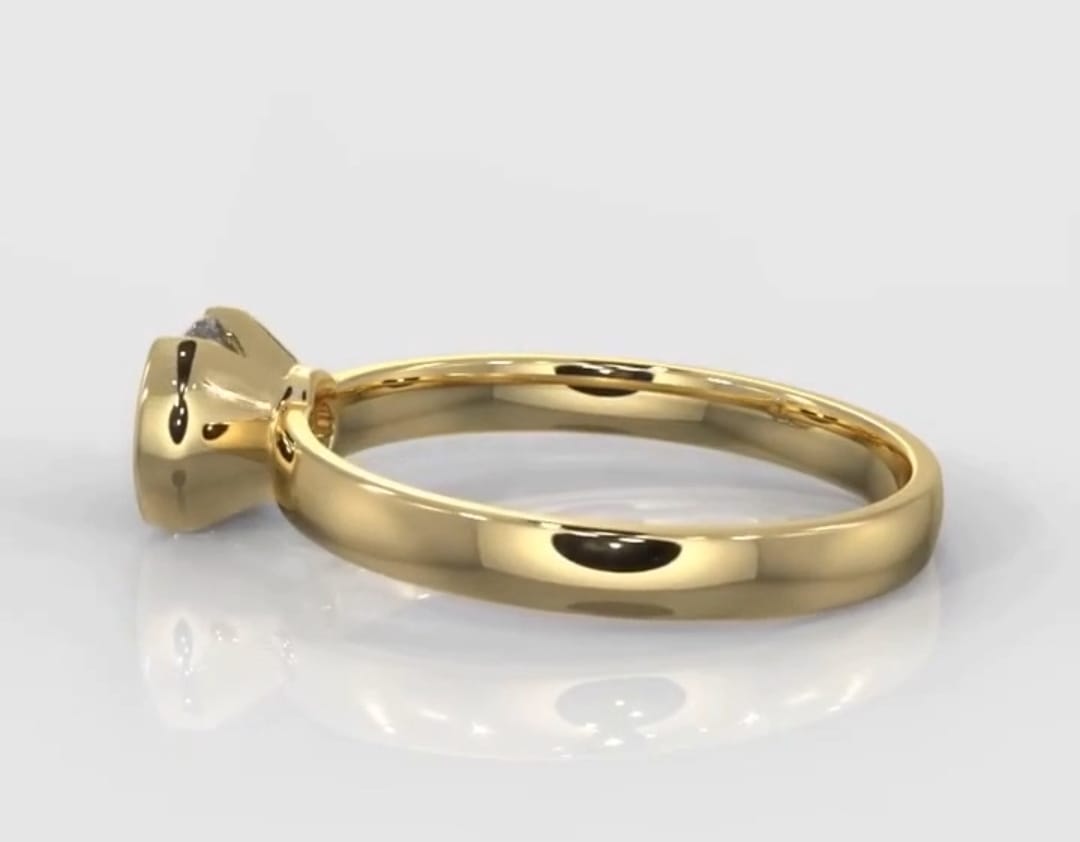 Side profile of a minimalist lab grown diamond ring with a polished yellow gold band.