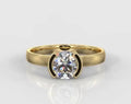 Top-down front view of a stunning 1.5 CT round cut lab grown diamond in a sleek half-bezel yellow gold ring.