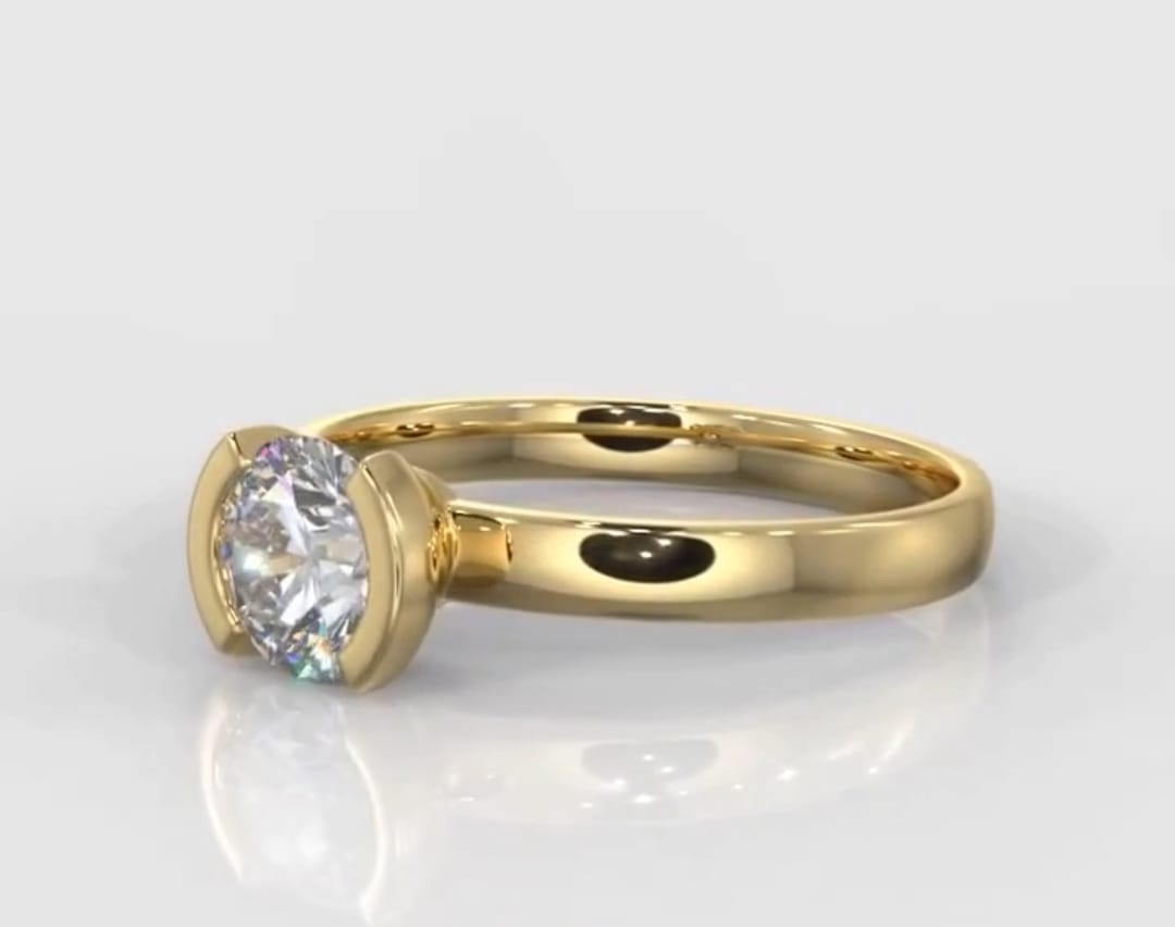 Angled front view of a modern half-bezel 1.5 carat round lab grown diamond solitaire engagement ring.