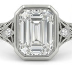 Close up top view of a 5 CT emerald cut lab grown diamond in a secure bezel setting with milgrain edges.