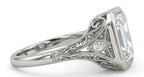 Side profile of a vintage style engagement ring showcasing intricate filigree, milgrain details, and an elevated bezel setting.
