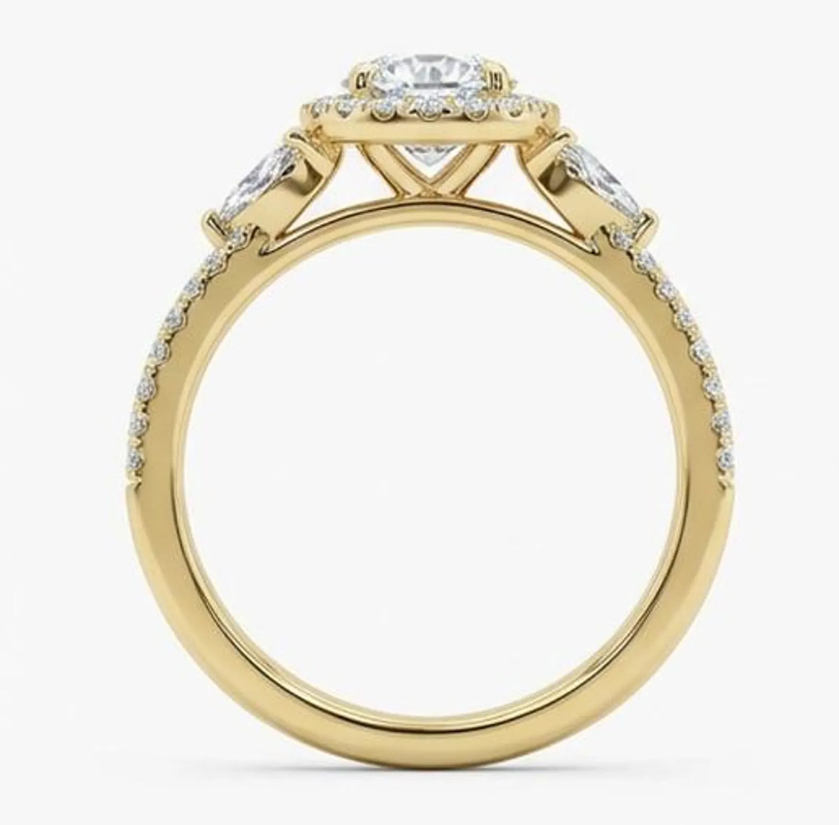 Side profile of a yellow gold round cut lab grown diamond engagement ring showing the prong setting and diamond band.