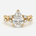 Top view of a 3 carat pear cut lab grown diamond engagement ring featuring a nature-inspired twisted vine band in yellow gold.