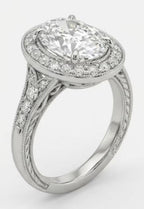 Angled view of a vintage style oval lab grown diamond ring featuring a pave diamond band and milgrain edges in white gold.