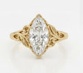 Top-down view of a 3 carat marquise cut lab grown diamond ring with carved botanical leaf accents in yellow gold.