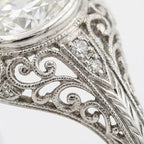 Close-up detail of hand-carved milgrain, filigree scrollwork, and diamond accents on a vintage lab diamond ring band.