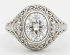 Top-down view of a 3 CT oval cut lab grown diamond set in an ornate vintage bezel filigree mounting.