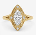 Top-down view of a 2 CT marquise cut lab grown diamond ring in yellow gold with an ornate filigree halo and milgrain borders.