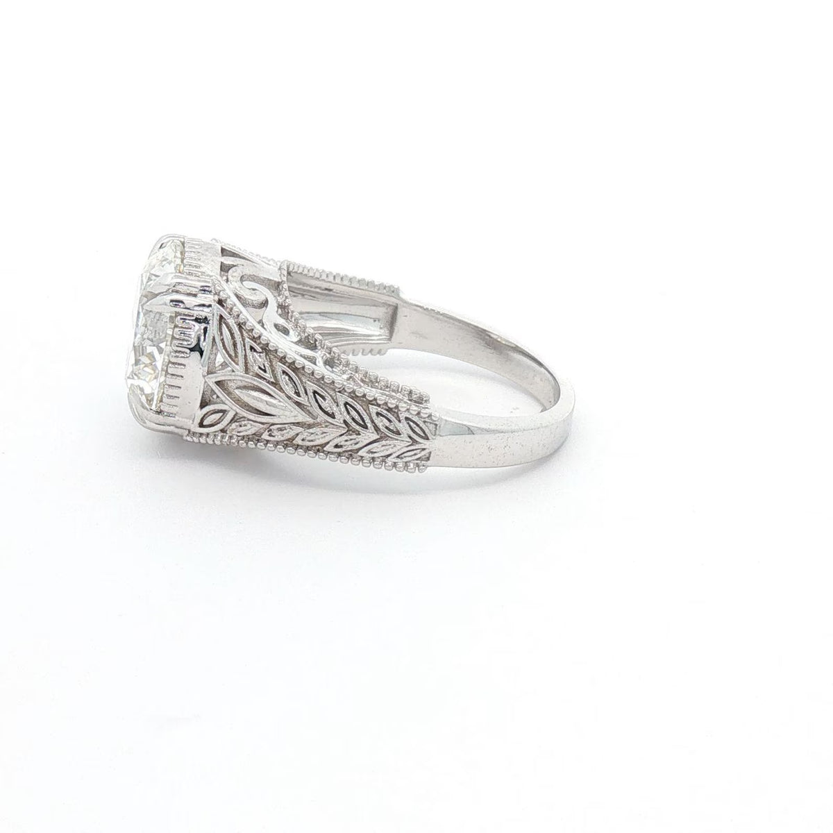 Side profile view of 4 CT round lab grown diamond ring with vintage leaf filigree and milgrain band.