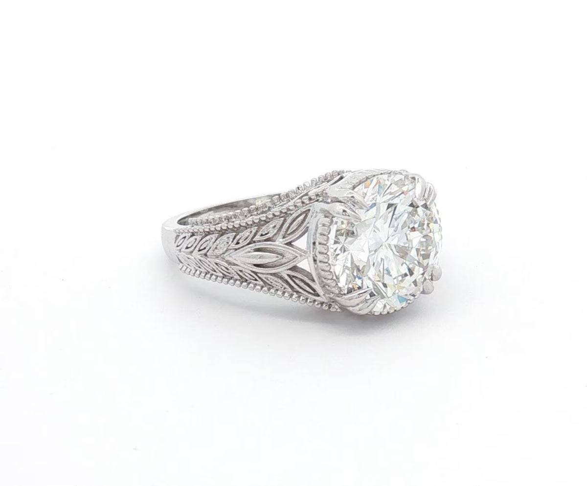 Angled view showing brilliant 4 CT round lab diamond set in a botanical leaf-detailed setting.