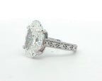 Angled view showing milgrain borders and hand-carved scroll engraving on white gold ring