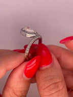 Side profile view showing halo setting and side pavé band detail of pear cut diamond ring.