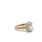 Perspective view of 3 carat oval lab grown diamond ring on carved yellow gold band.