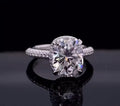 Close-up front view of a 3 carat elongated cushion cut lab grown diamond on a paved white gold band.