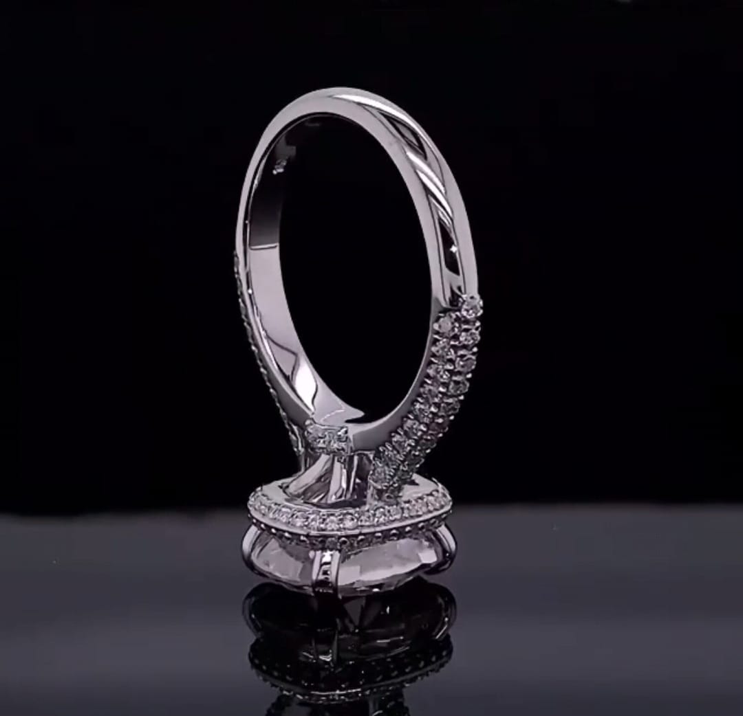 Vertical view showcasing under-halo and pavé band architecture of a cushion cut diamond ring.