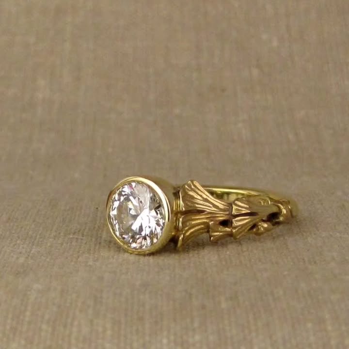 Close-up of side carved leaf texture on a yellow gold 2 CT round diamond bezel setting.