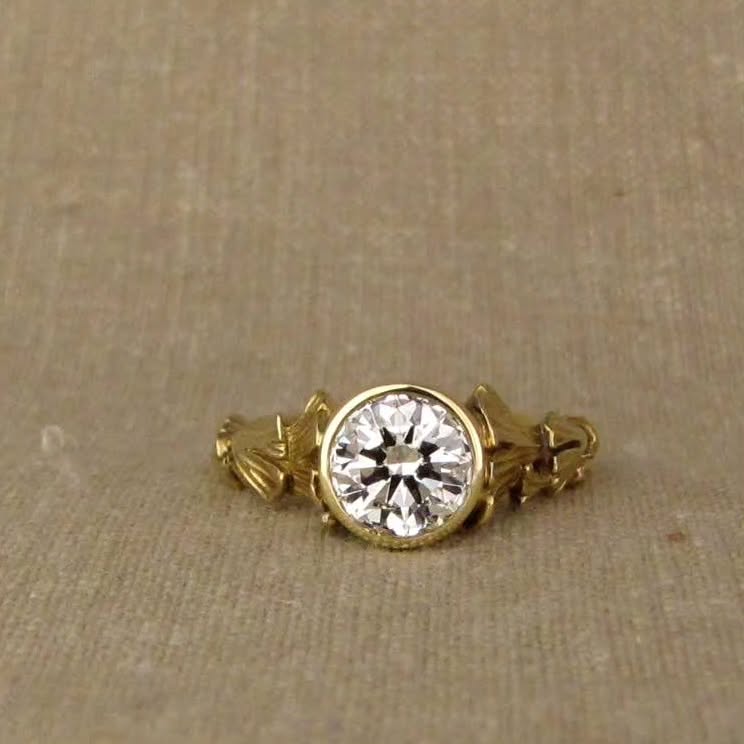 Direct top view showing round brilliant lab grown diamond set in a sleek yellow gold bezel frame.