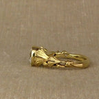 Horizontal side profile showing the continuous sculpted foliage details on a gold diamond ring band.