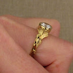 On-finger perspective displaying side leaf texture and bezel setting height of a round diamond ring.